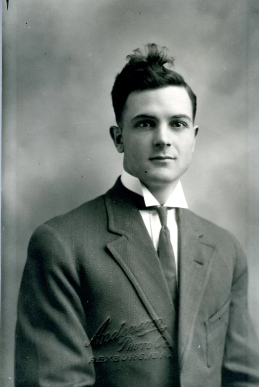 black and white pograph of young man wearing a suit