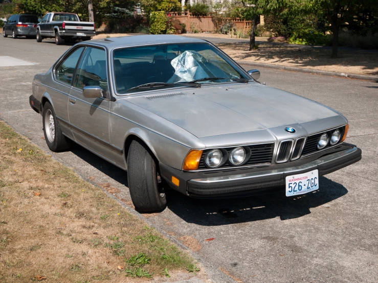 this bmw coupe is parked on the side of a road