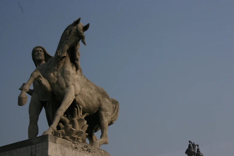 a statue of a horse and a rider stands next to each other on the roof