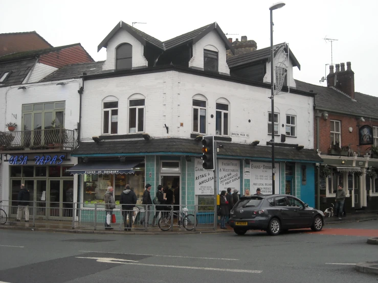 a street corner with stores and people standing in the street