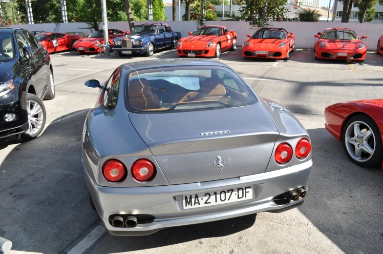 a row of red sports cars in parking lot