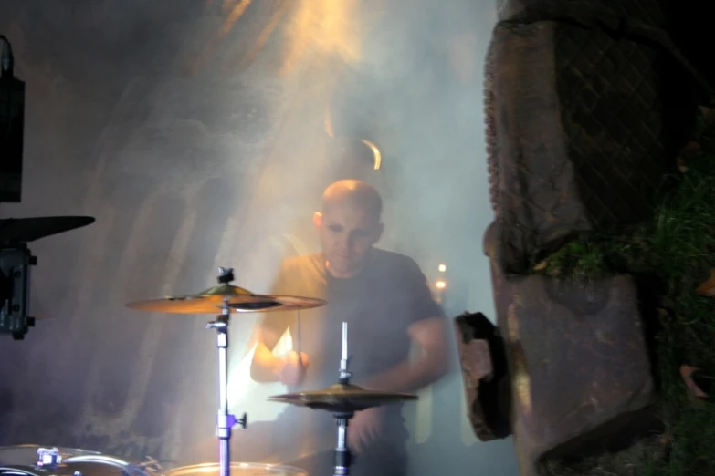 a man playing a musical instrument with smoke around him
