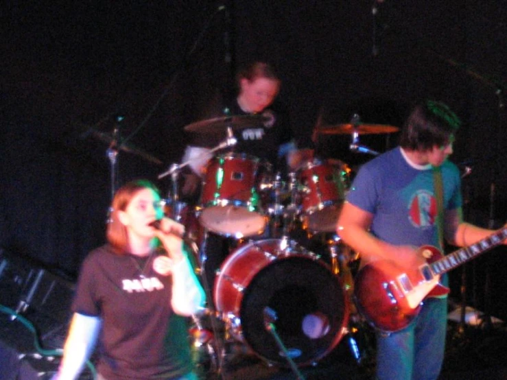people on stage playing music with a microphone