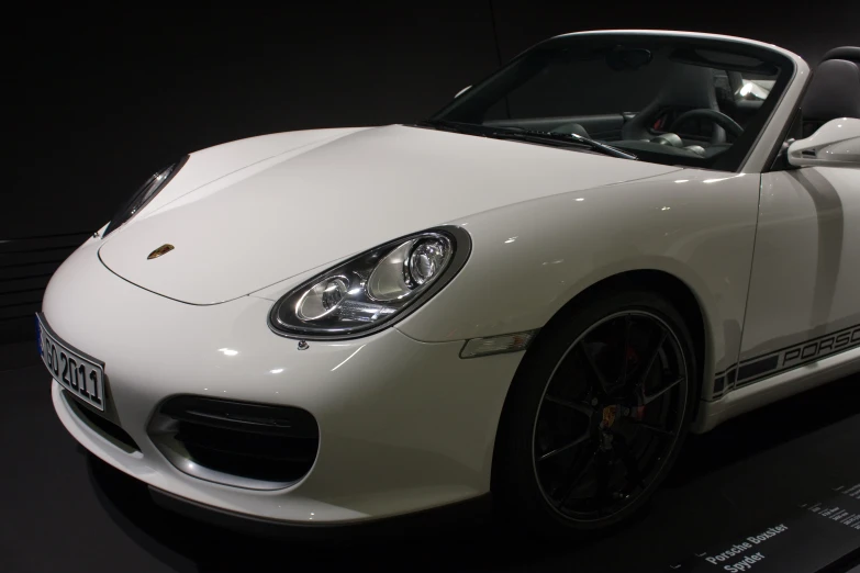 a white sports car with black wheels in a display