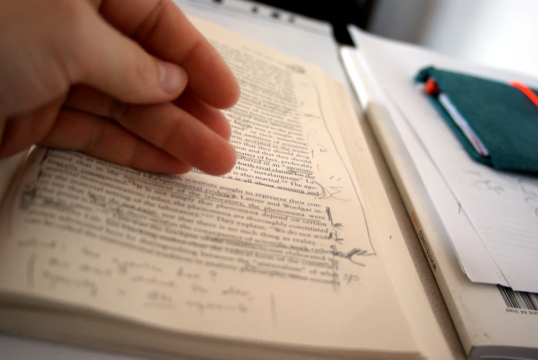 a person's hand on an open book