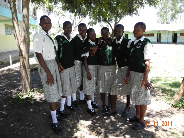 school boys pose for a picture under a tree