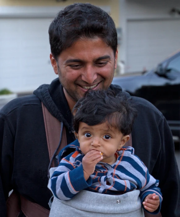 a man holds a baby boy that is in his lap