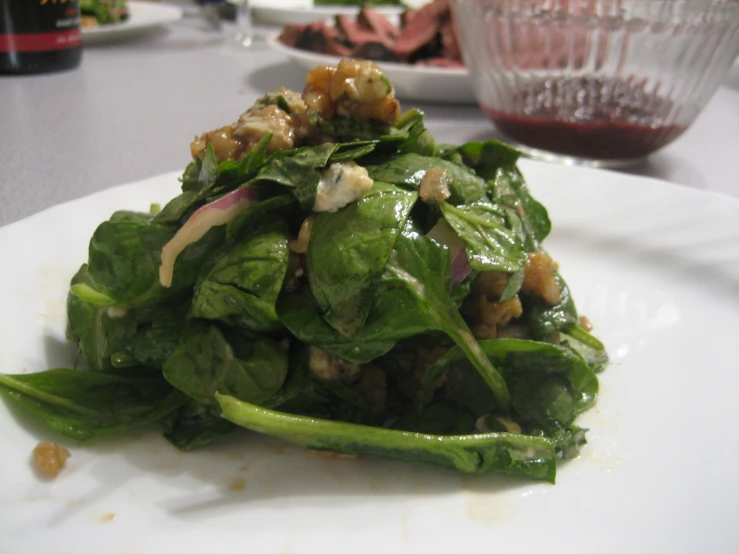 a white plate filled with spinach salad