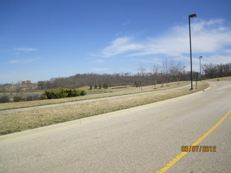 a empty country road with trees and a sign