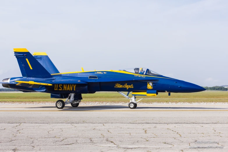 a blue and yellow fighter jet parked in an airport