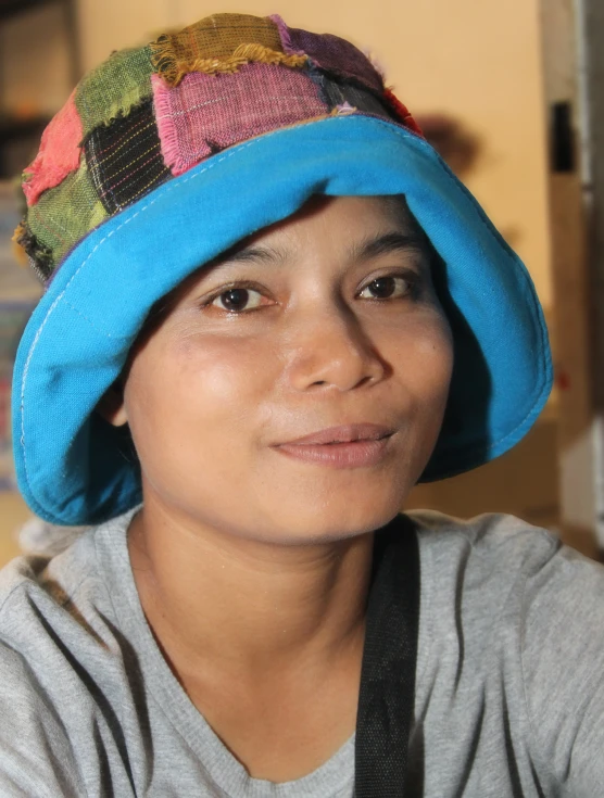 a woman wearing a blue bucket hat in a kitchen