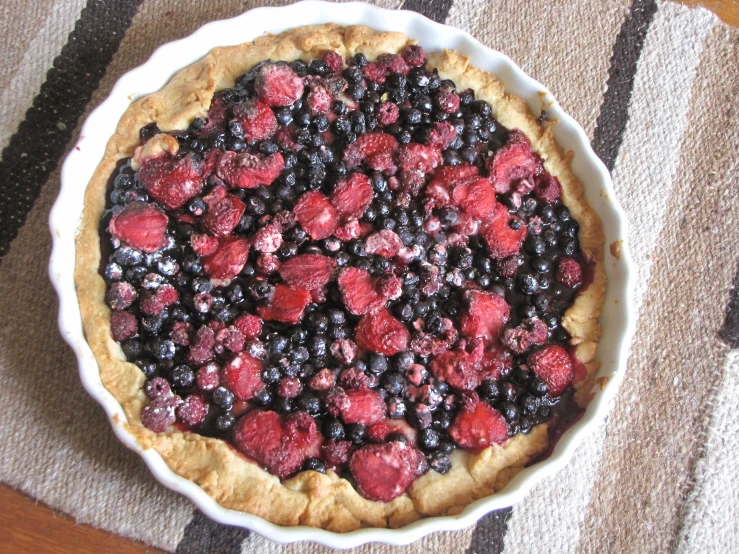 a pie is decorated with fresh berries and blueberries