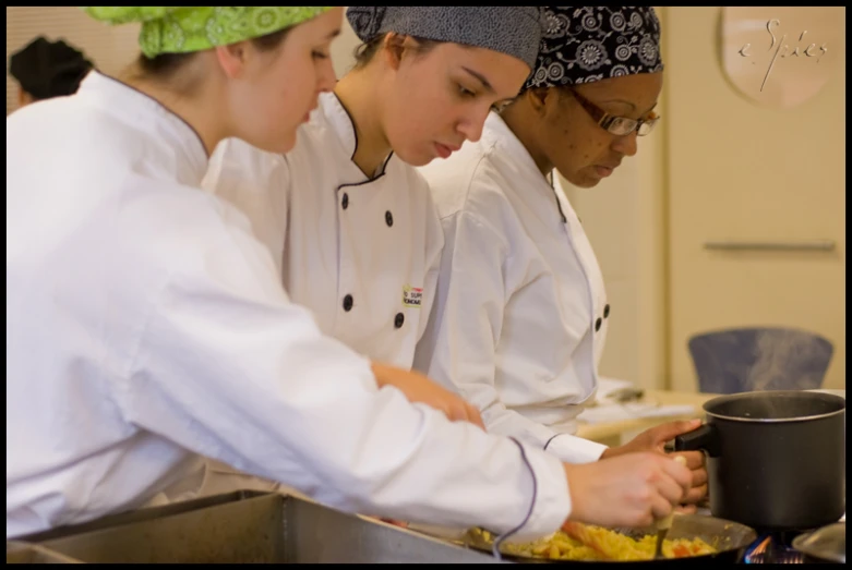 three people working on cooking in a large kitchen