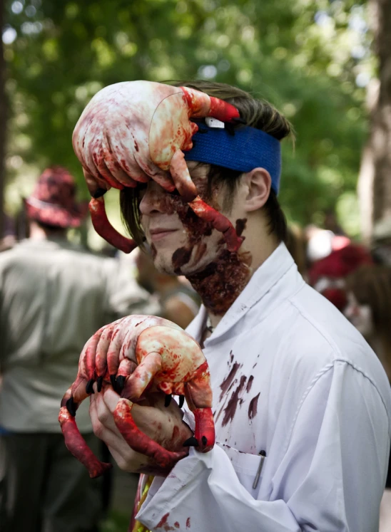 a man dressed in zombie costume holding open  hands