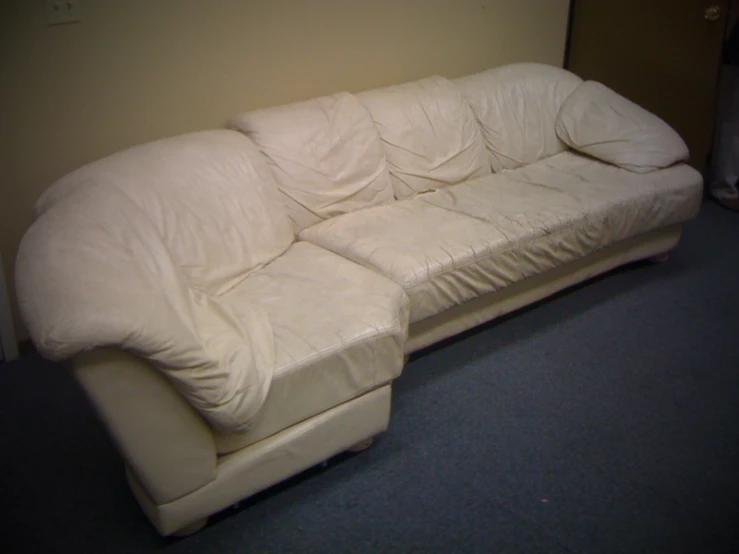 there is a white couch with two pillows on it