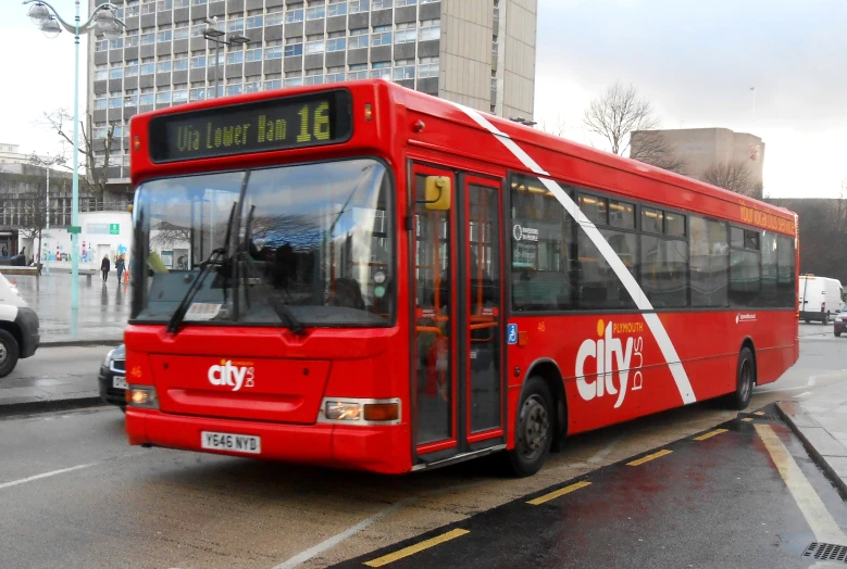 a bus driving down the road with a person sitting on it