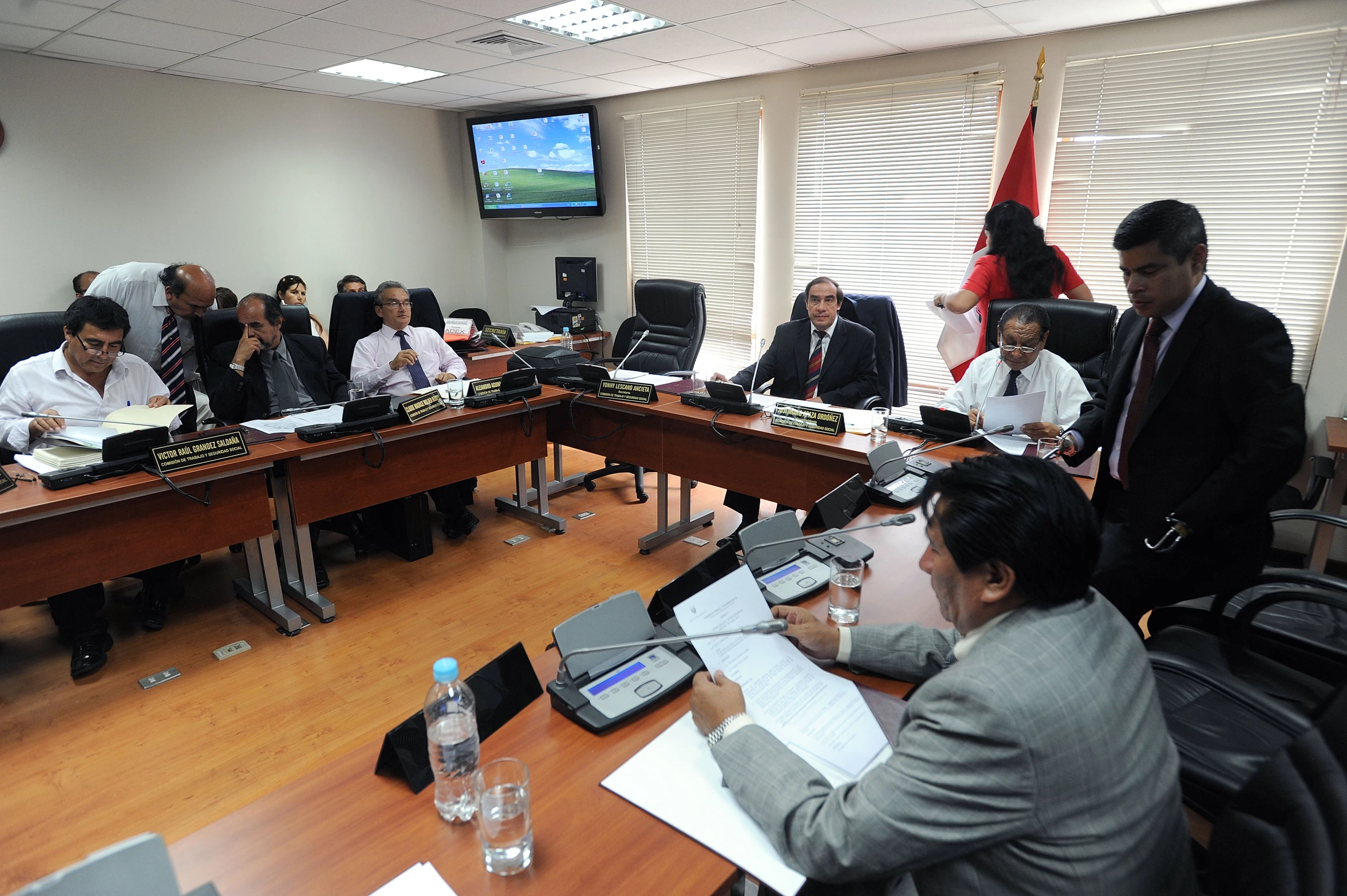 a group of men in a meeting room working on paperwork