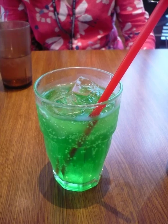 there is a green drink in the cup on the table