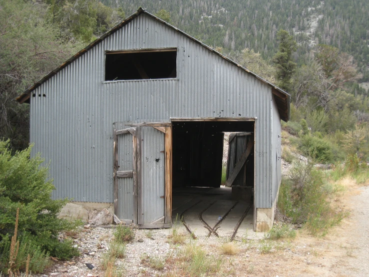 a building with two doors opened and some bushes