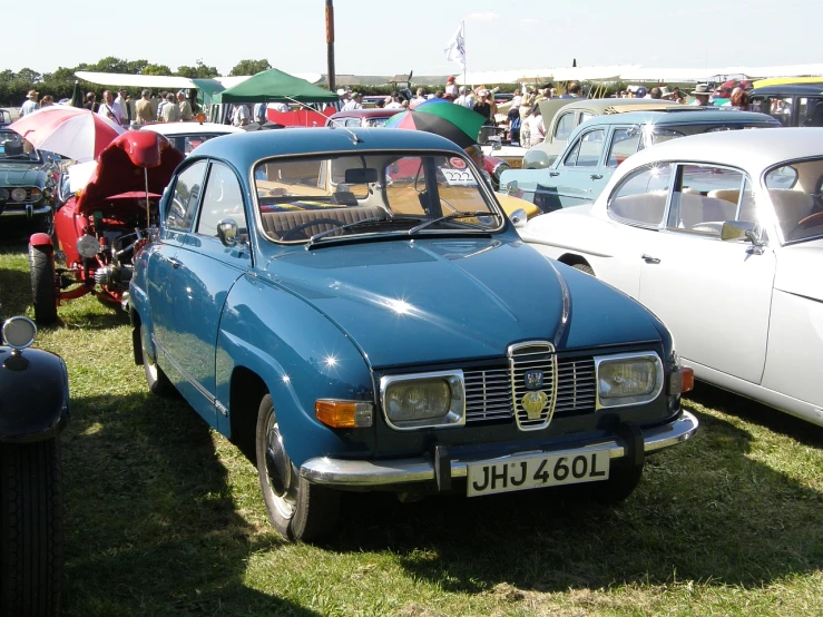 a blue car is parked in the middle of a crowd