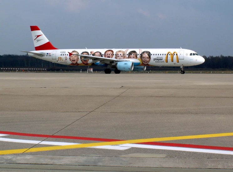 a large commercial airline with portraits painted on the side of it