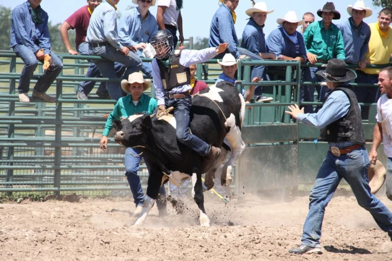 a man in cowboy hats riding a bucking horse