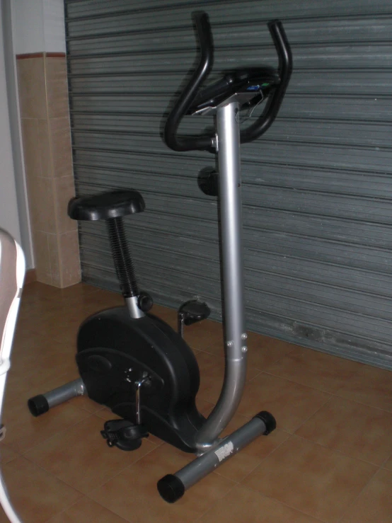 the bike and exercise machine is next to a wall