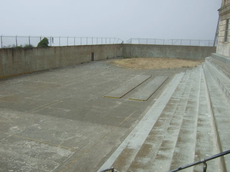 an empty basketball court next to a fence