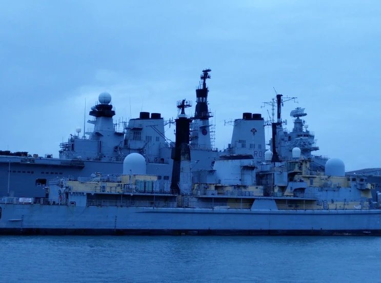 an aircraft carrier sits in the water