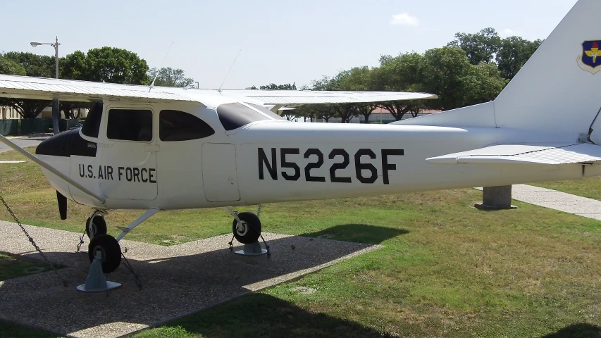 an small propeller plane on display in a grass field