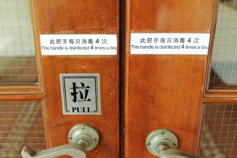 two metal handles with stickers in english and japanese