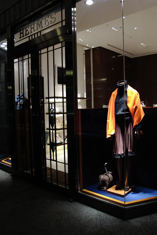 a mannequin standing outside a window display at night