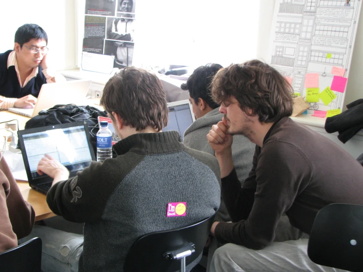 people sit around tables at various stages of a project