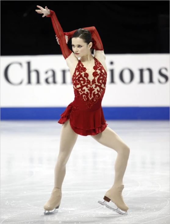 a female figure skater in red skating on the ice