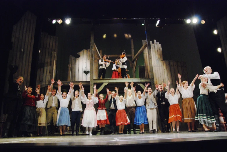 a group of people standing on a stage with their arms in the air