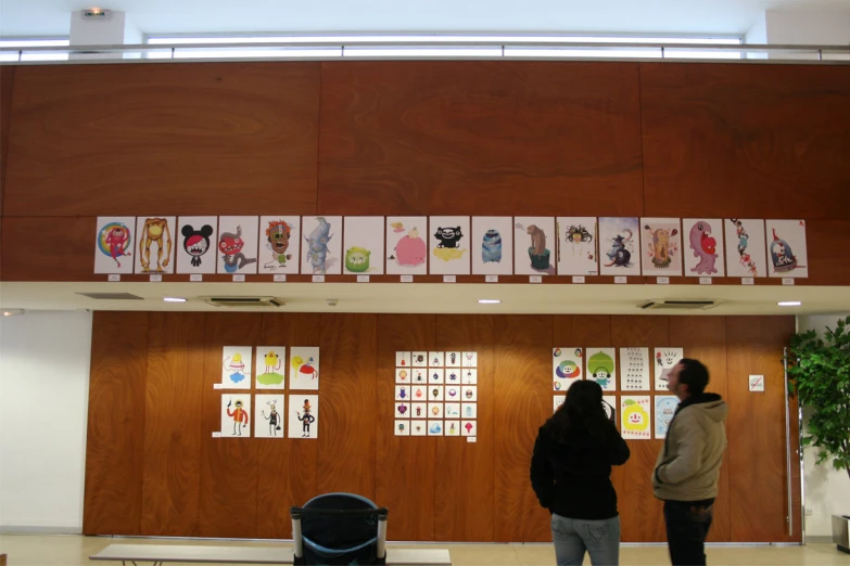 two people standing by a doorway in a room with pictures above the door