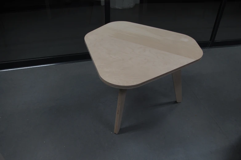 an unfinished table sitting on top of a gray floor