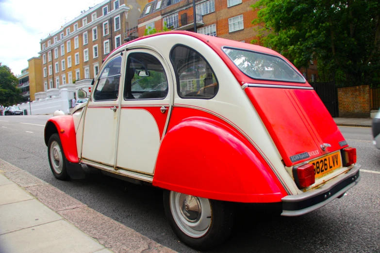 a red and white car that is parked on the side of a street