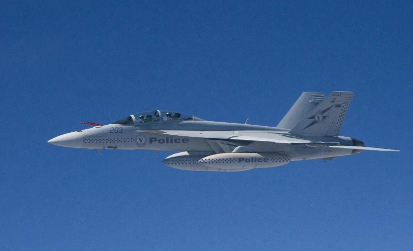 a military jet flying through the clear sky