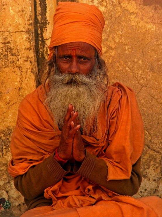 a man with a white beard sitting in front of a building