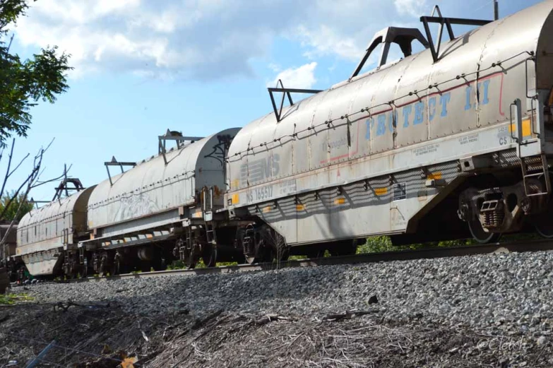 an old railroad train is parked near some rocks