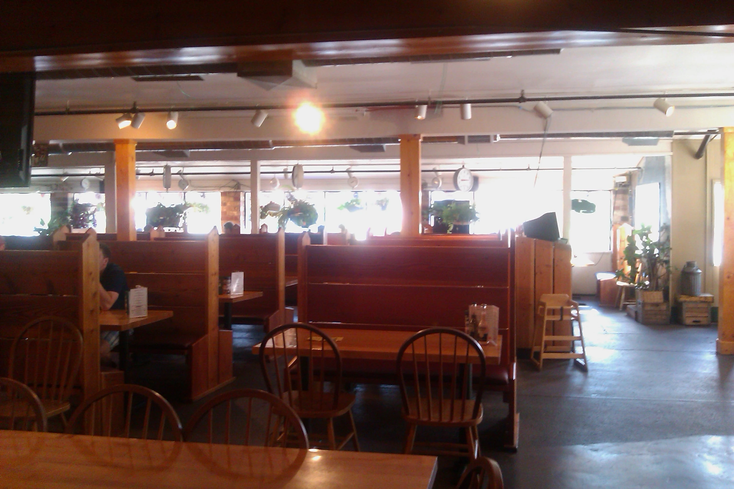 an empty restaurant with tables and wood booths
