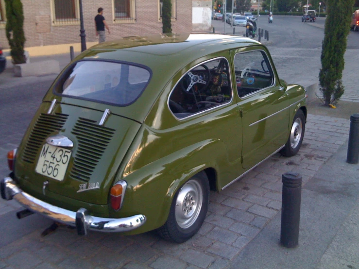 an old green car parked on the side of the road