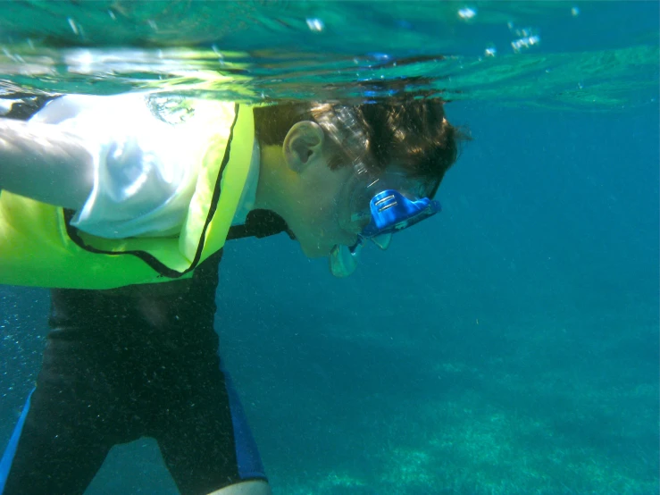 a  with a water bottle and glasses, looking into the blue water