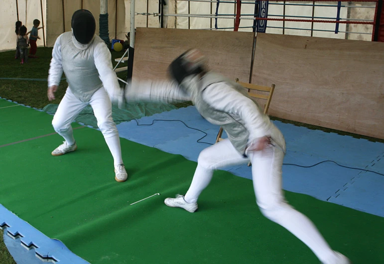 a blurry image of two people in fencing outfits