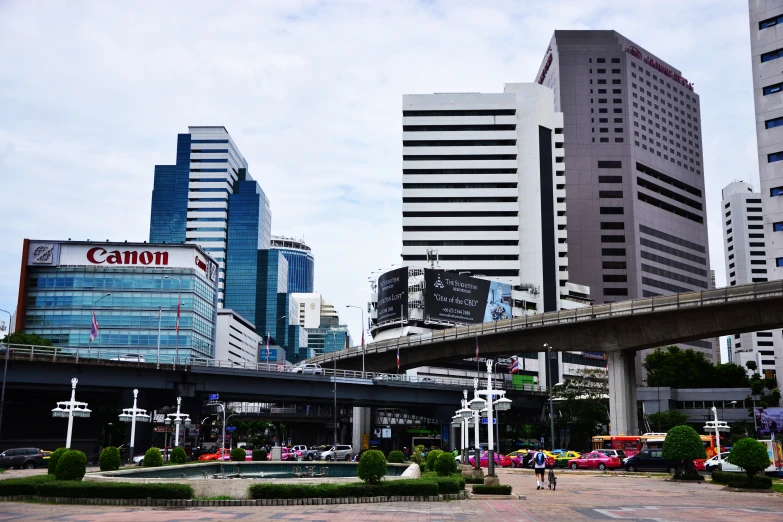 a city with skyscrs and a bridge over the road