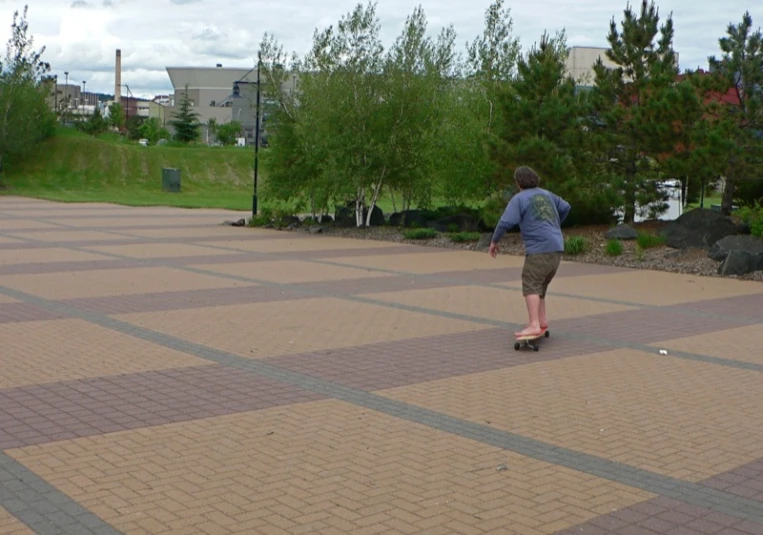 a boy skateboards down the street in an outdoor setting