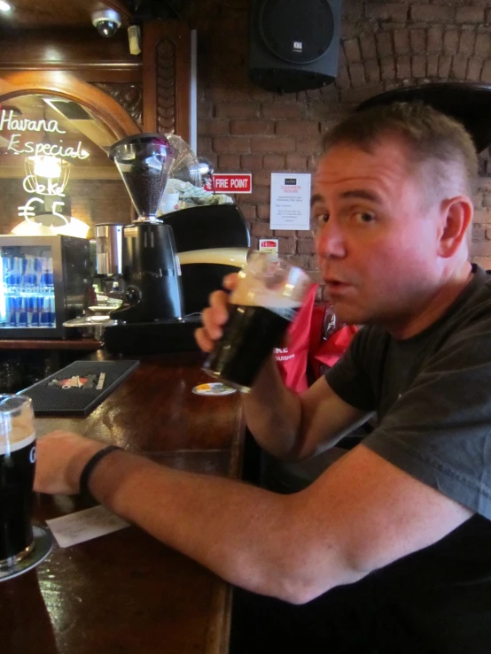 a man pouring glasses of beer at a bar