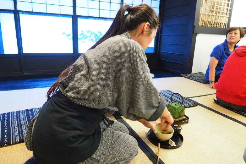 a woman that is sitting on the ground with potted plants