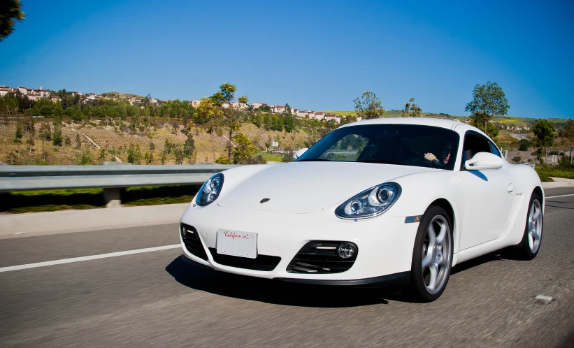 a white sports car is driving down the road